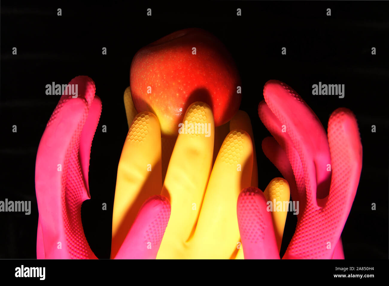 Composition abstraite avec des gants de caoutchouc et un apple Banque D'Images