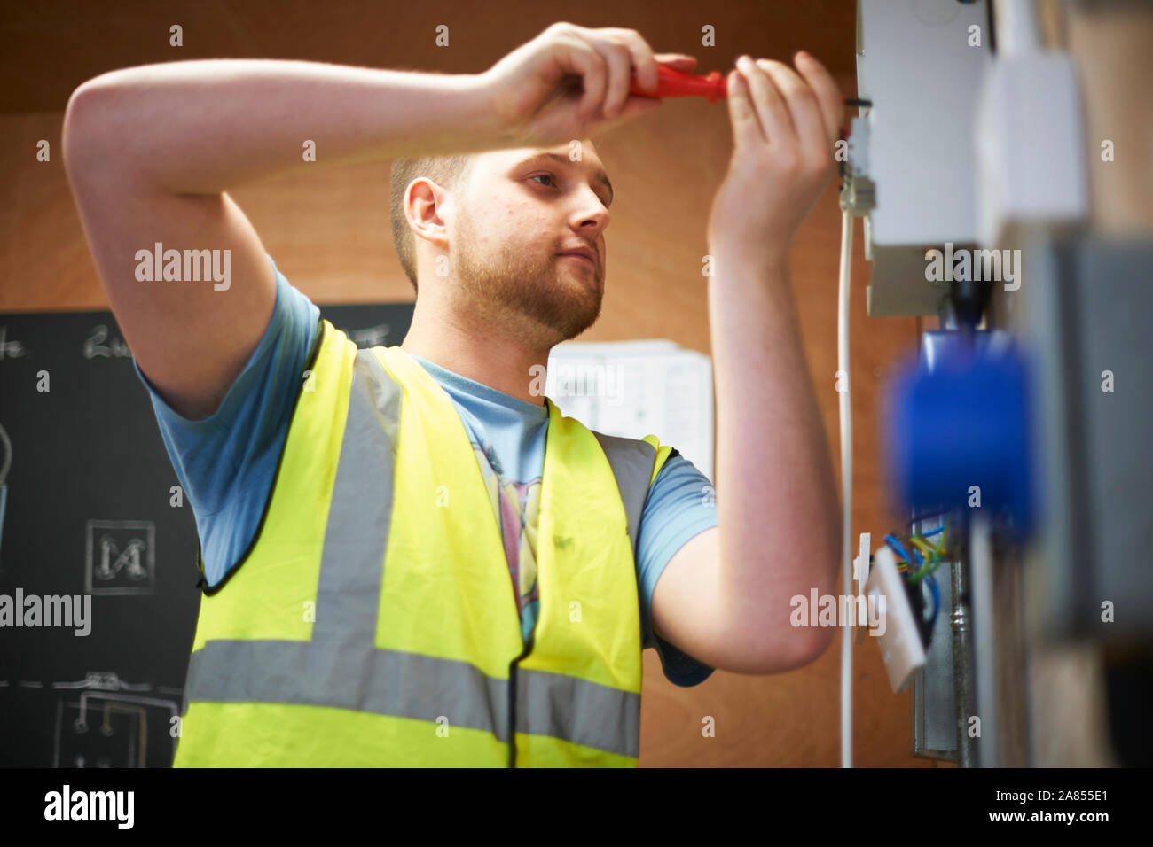 Male electrician étudiant en utilisant le tournevis Banque D'Images
