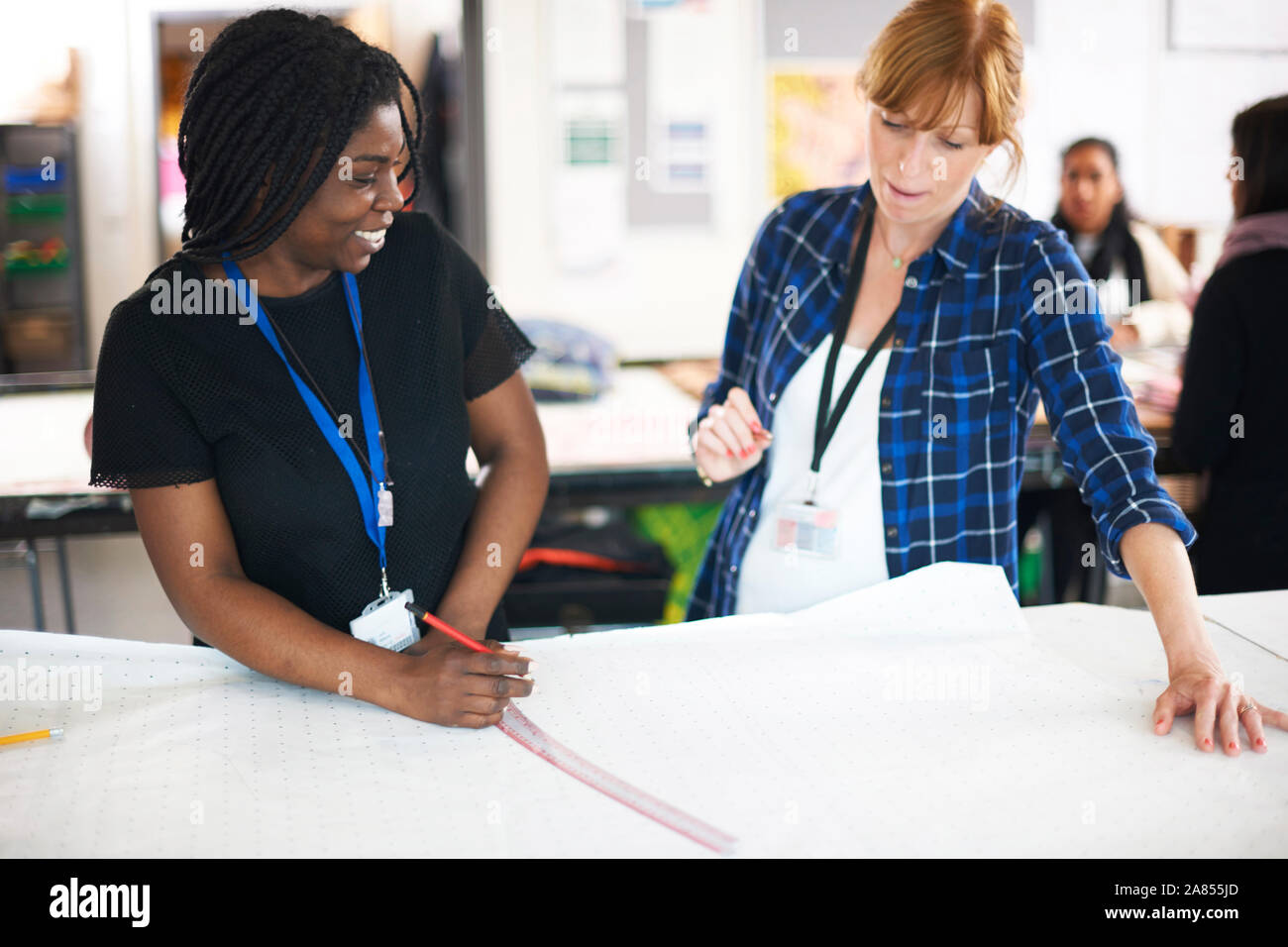 Les créateurs de mode féminine tendance robe de dessin en studio Banque D'Images