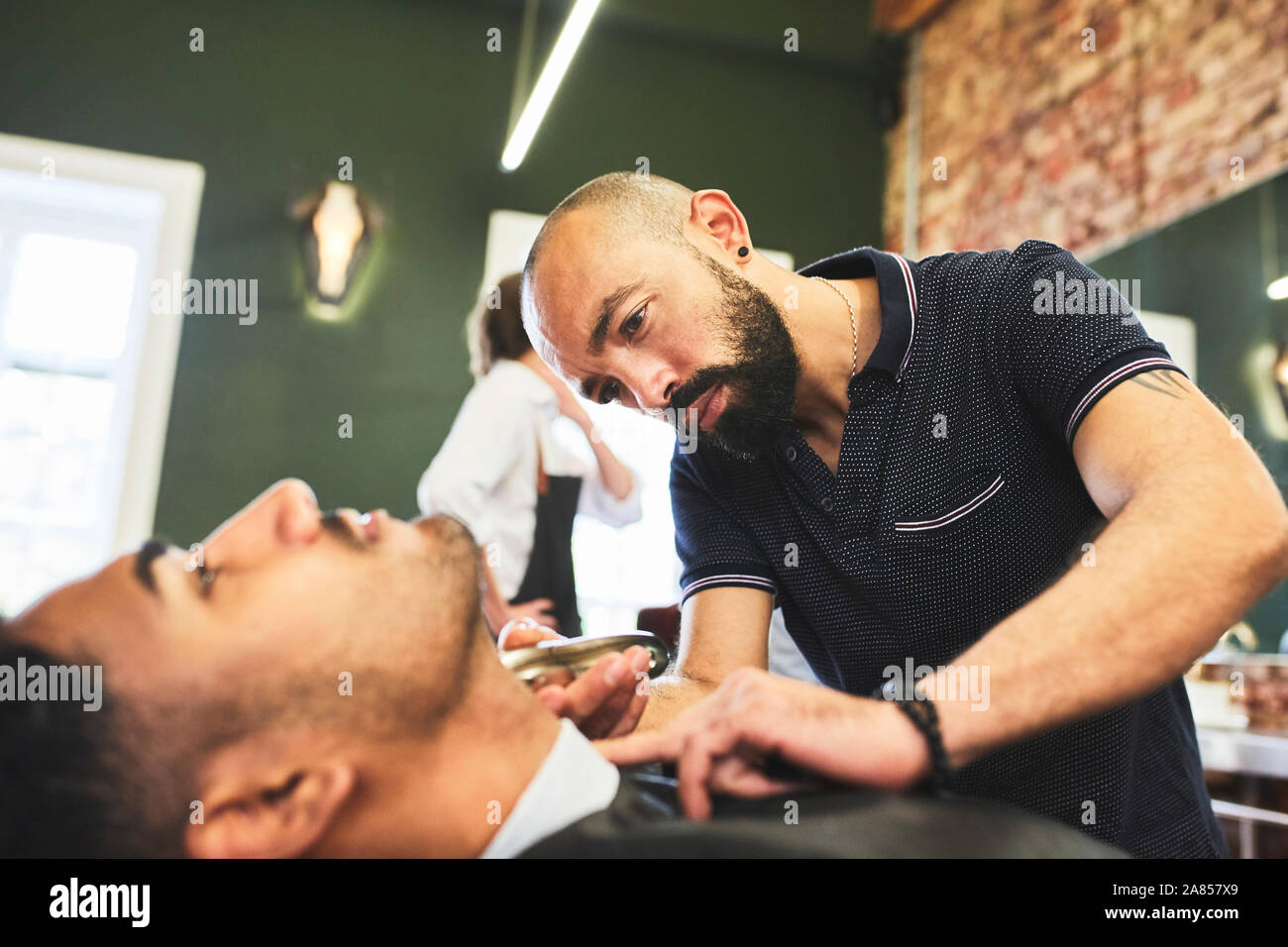 L'accent homme coiffure donnant un client dans ce type de rasage Banque D'Images