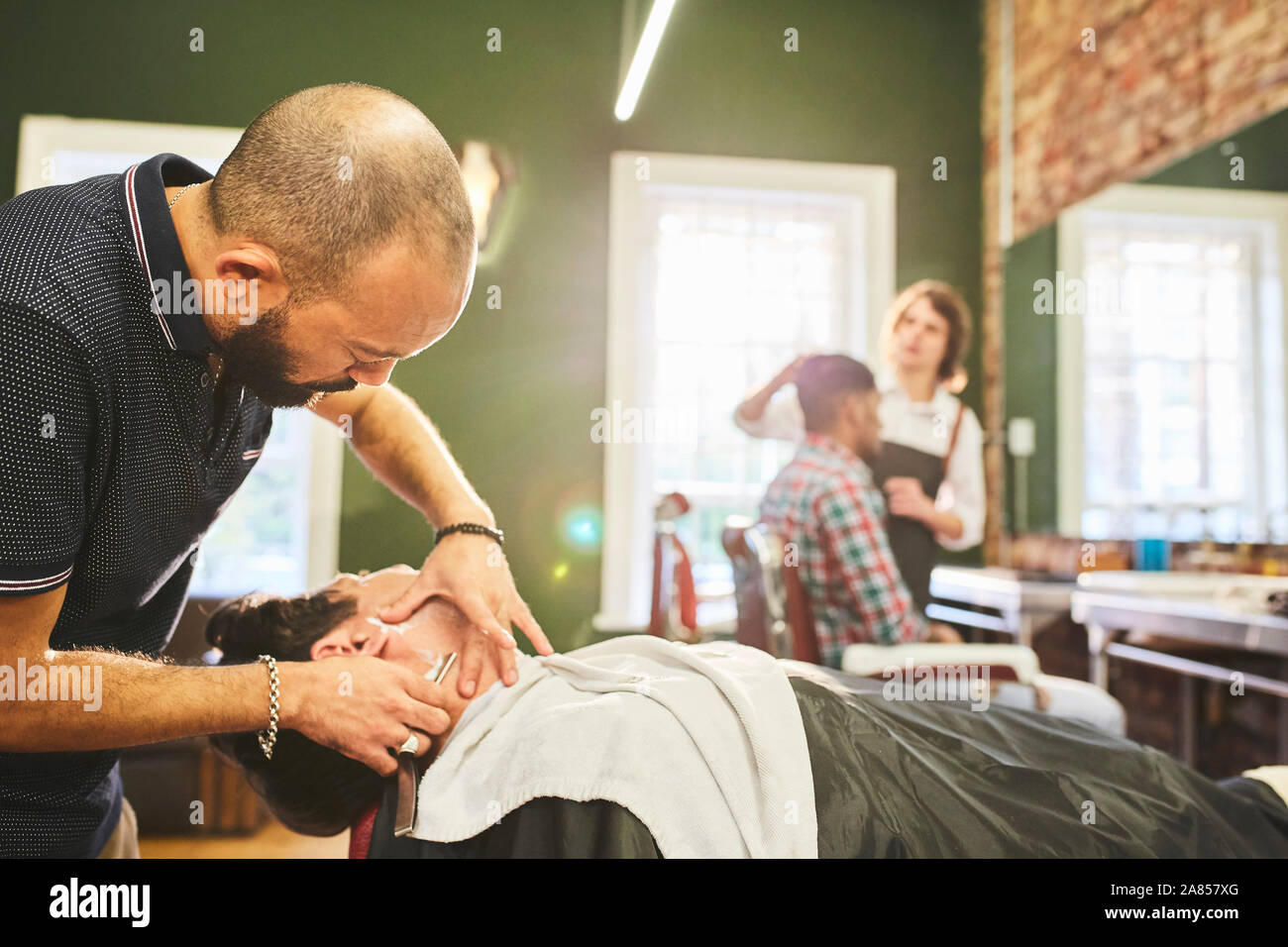 Coiffure homme visage rasage de client dans un salon de barbier Banque D'Images