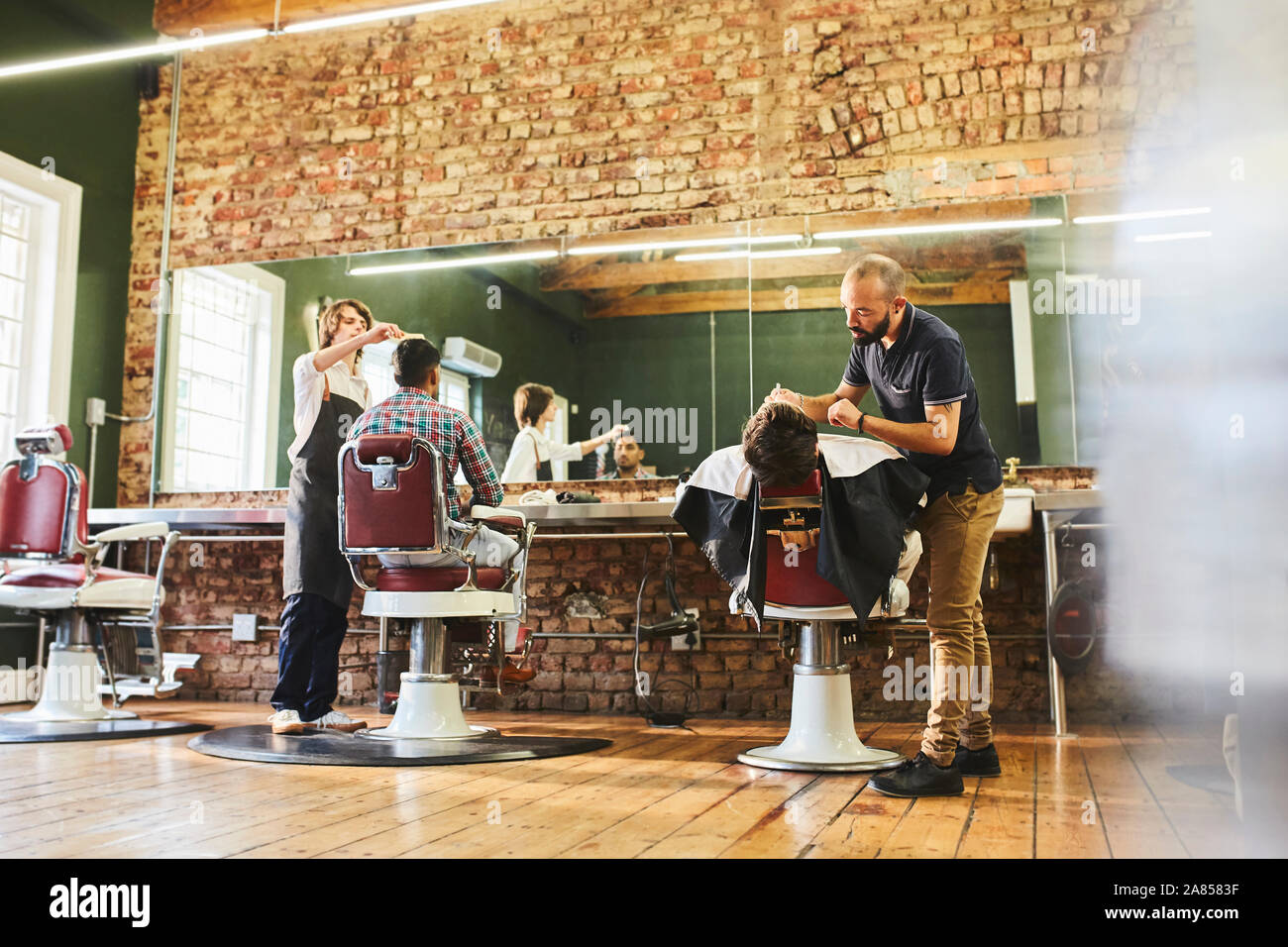Les barbiers et les clients de sexe masculin dans ce type de Banque D'Images