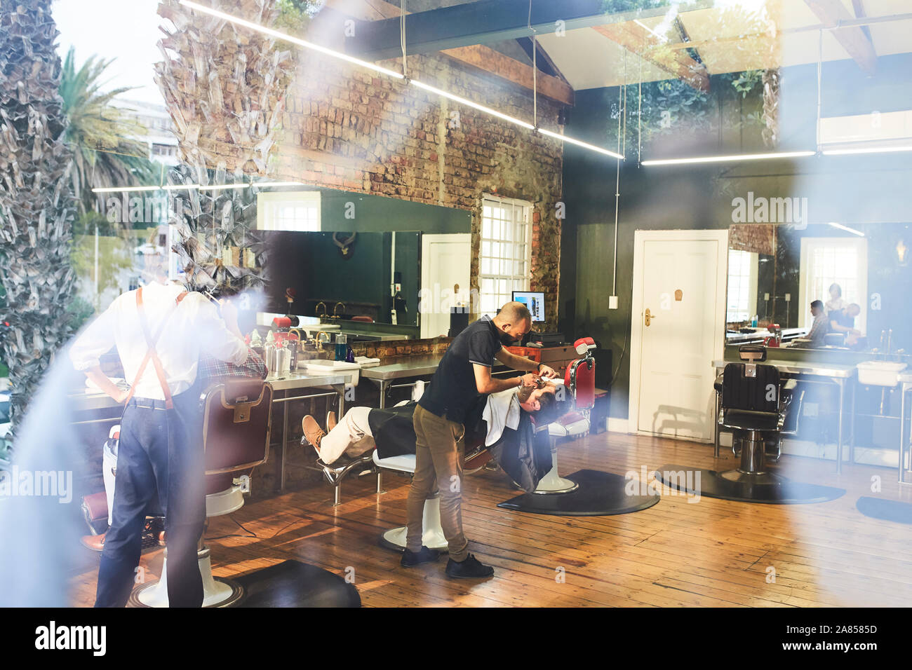 Coiffure homme visage rasage de client dans un salon de barbier Banque D'Images