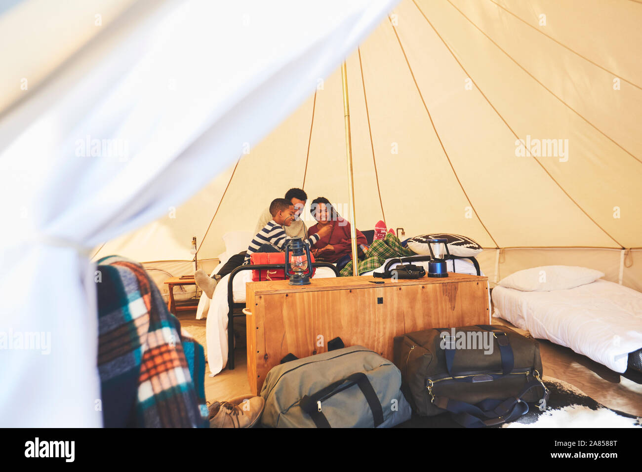 Family relaxing on bed à l'intérieur d'une yourte camping Banque D'Images
