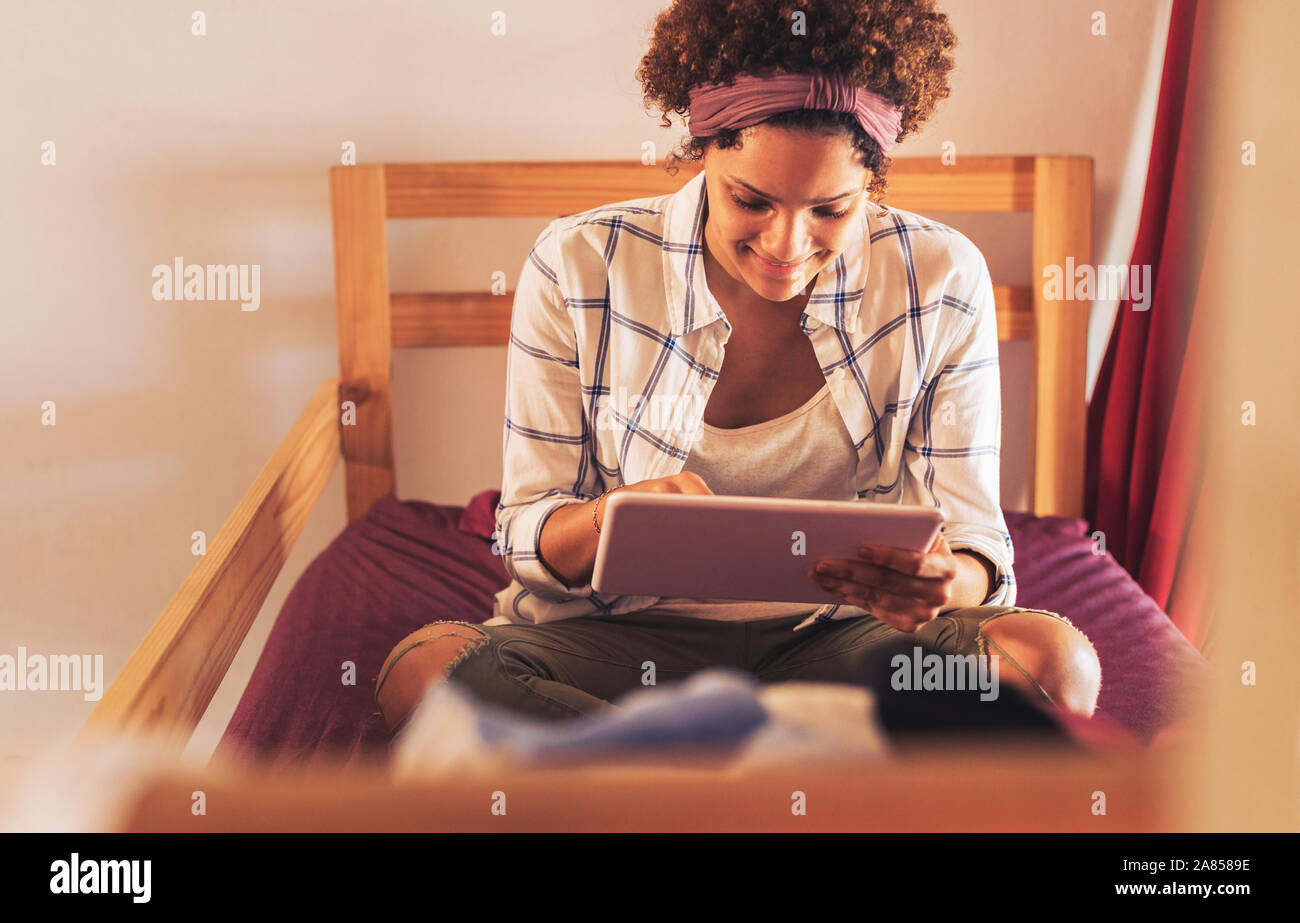 Young female college student using digital tablet on chambre dortoir lits superposés Banque D'Images