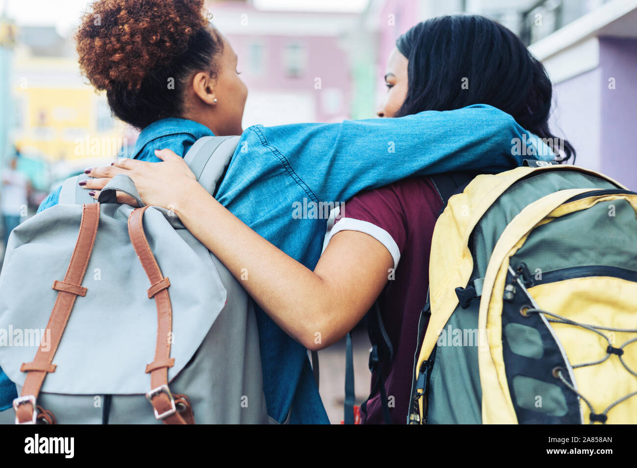 Young women friends avec sacs à dos hugging Banque D'Images