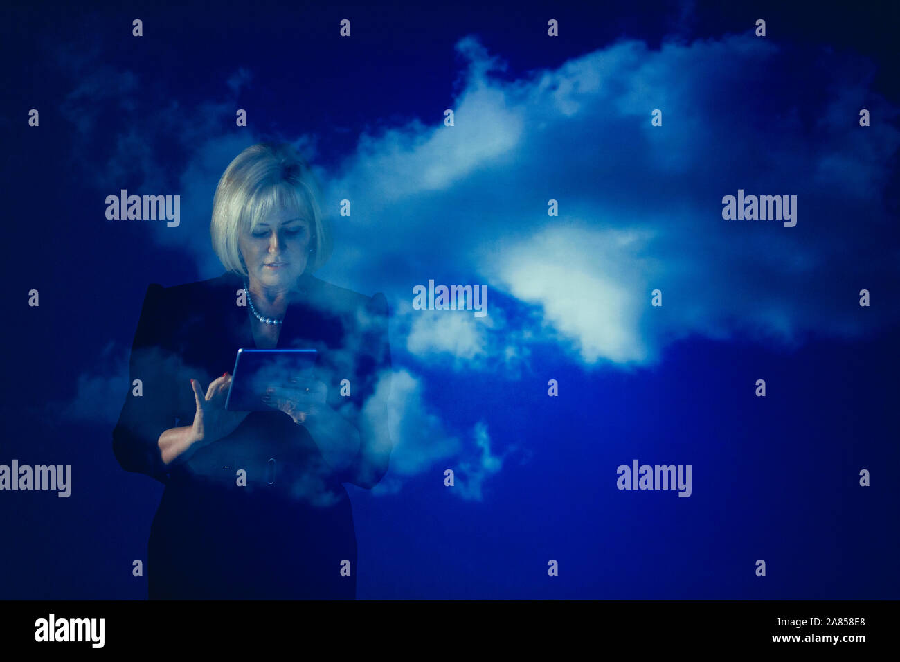 Double exposition businesswoman with digital tablet against blue sky with clouds Banque D'Images