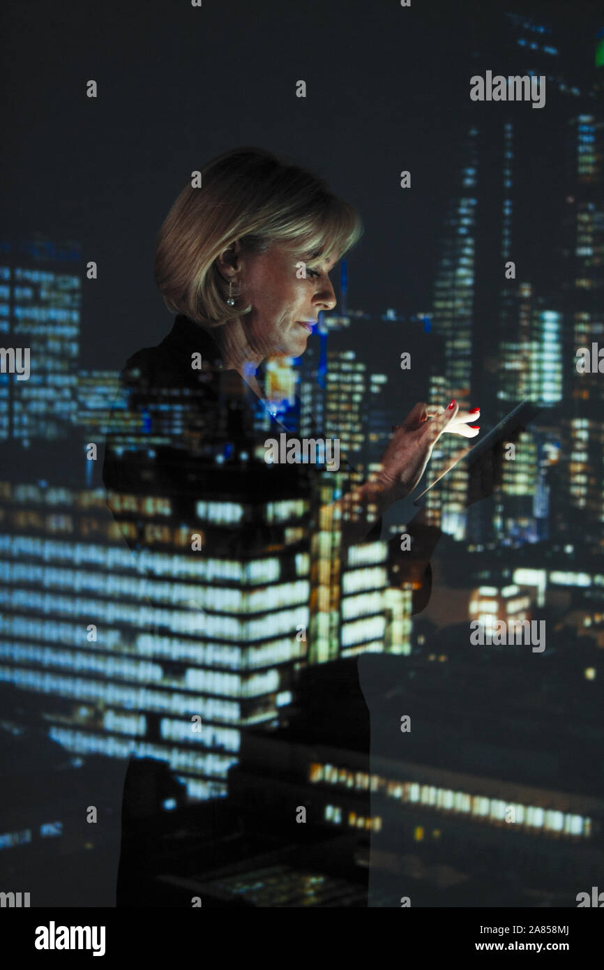 Double exposition businesswoman with smart phone contre highrise des lumières dans la nuit Banque D'Images