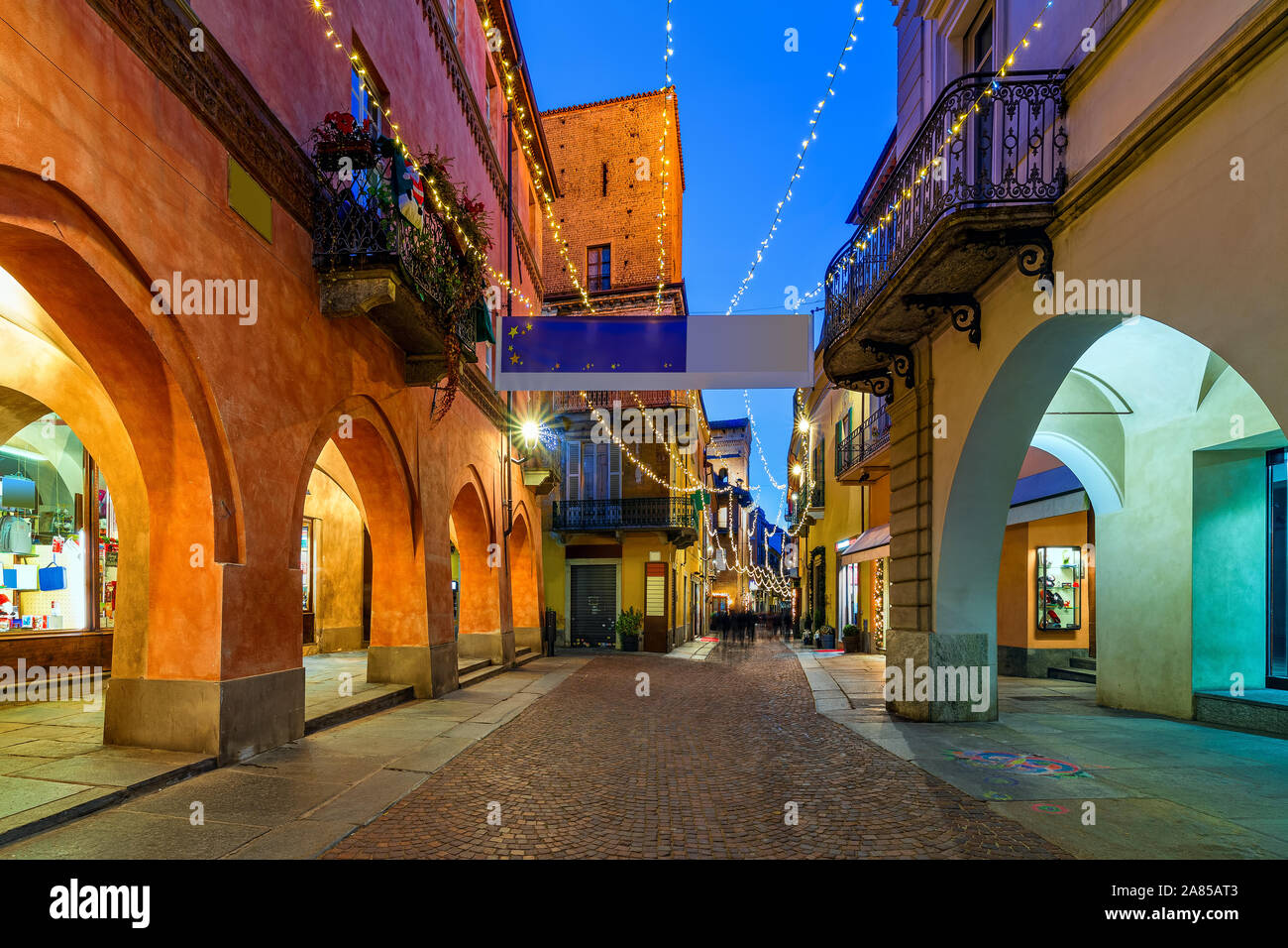 Rue pavées étroites avec l'illumination de Noël dans la vieille ville d'Alba dans le Piémont, Italie du Nord. Banque D'Images