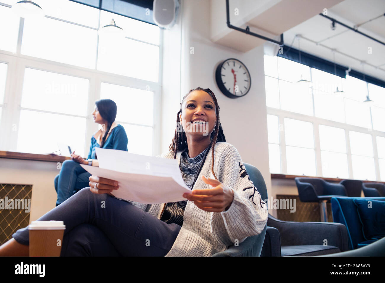 Heureux, confiant businesswoman with paperwork in office Banque D'Images