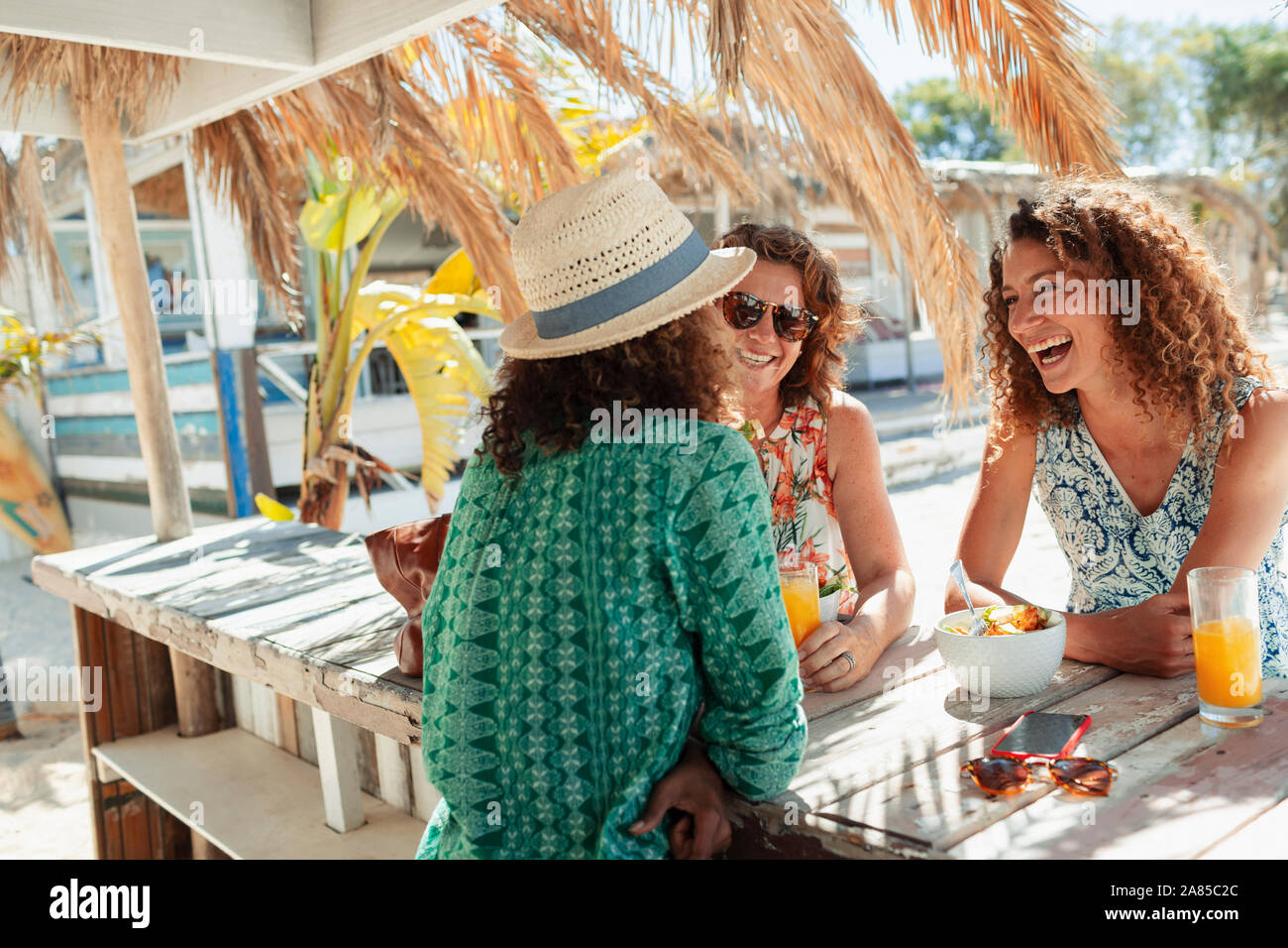 Happy women eating petit-déjeuner à sunny beach bar Banque D'Images