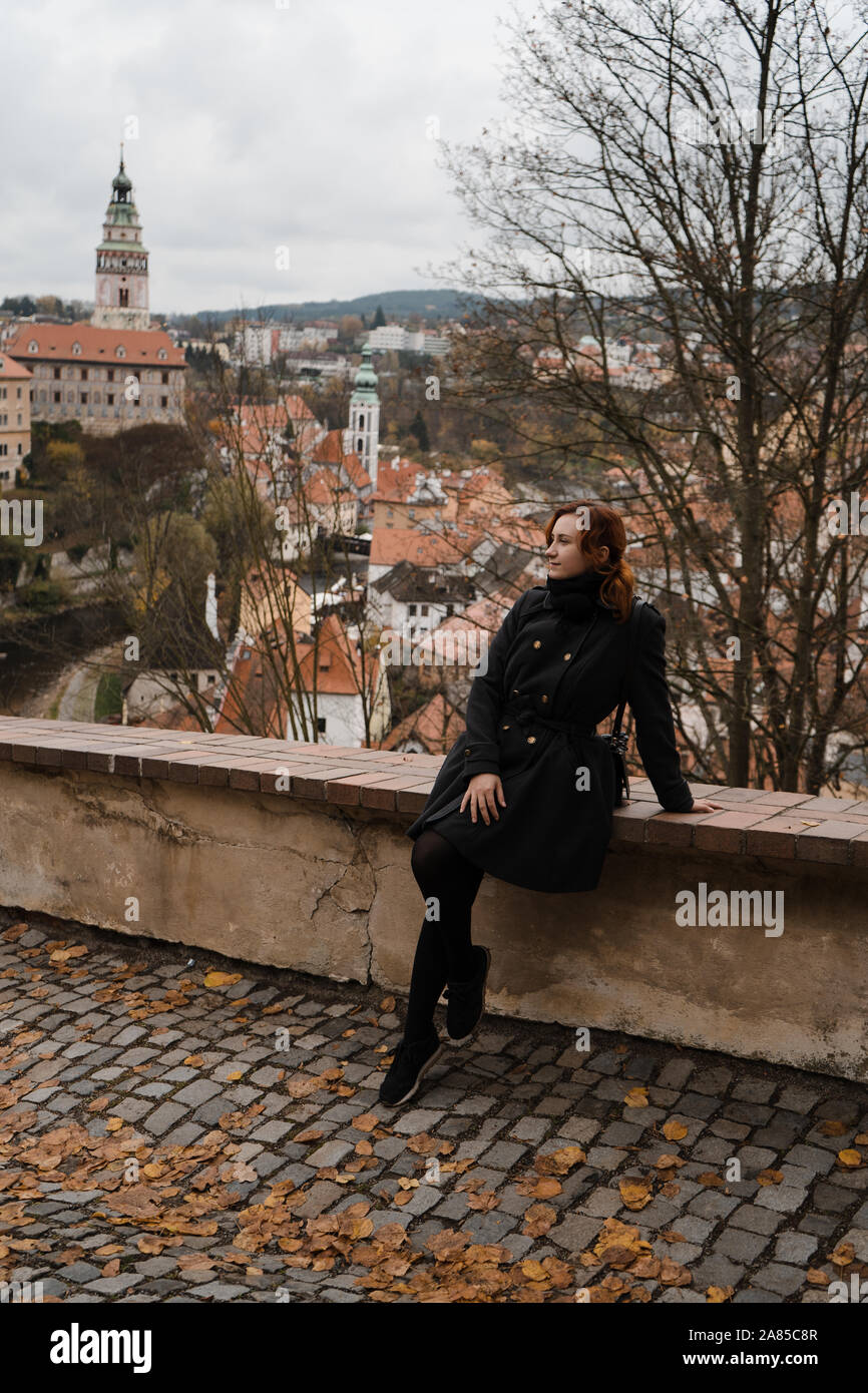 Redhead happy woman in Cesky Krumlov avec une vue sur les toits du centre-ville, château et Église de Saint Vitus Banque D'Images