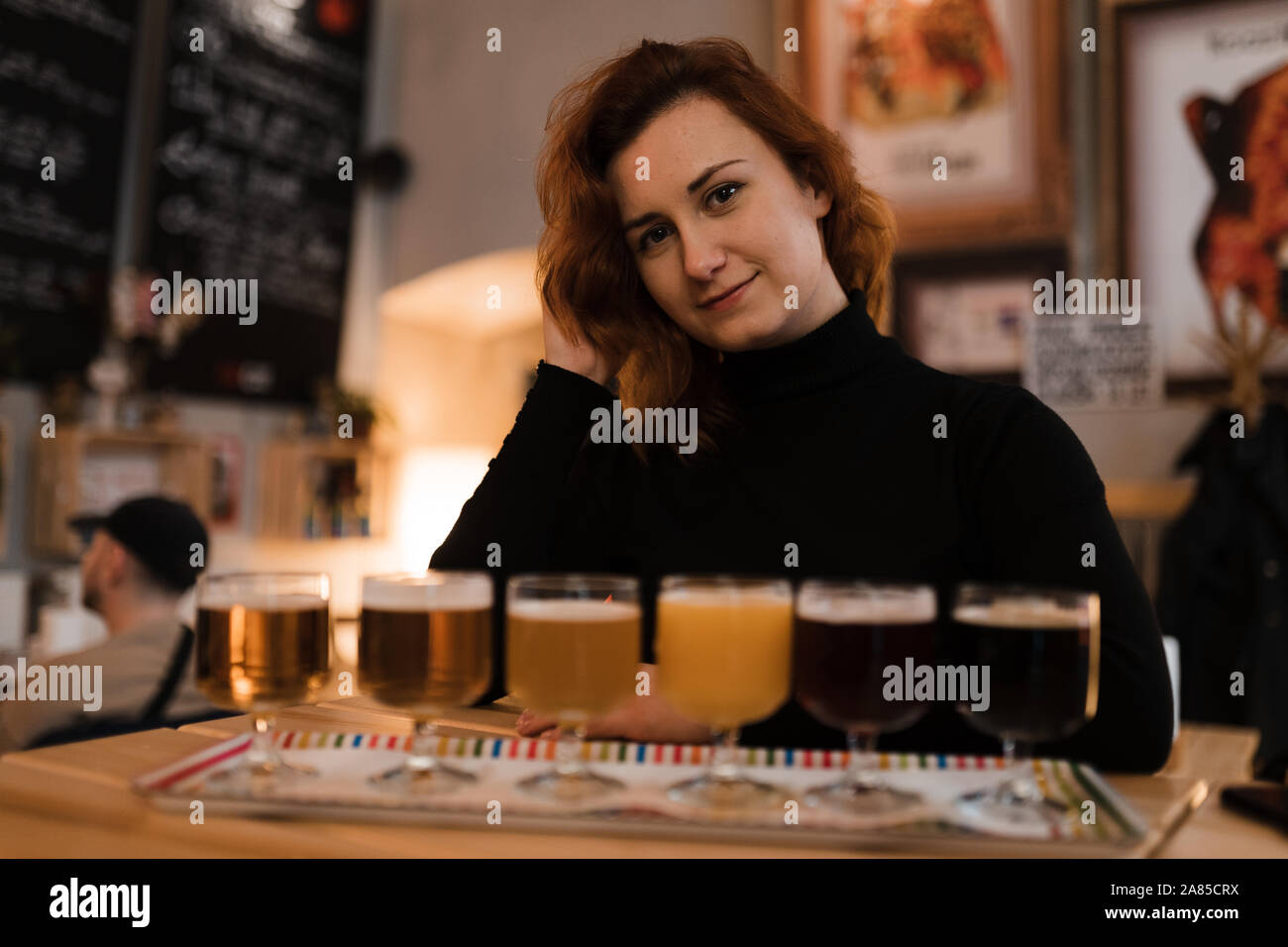 Femme rousse ne une dégustation d'une variété de la lumière et l'obscurité de la bière tchèque dans un bar pub Banque D'Images
