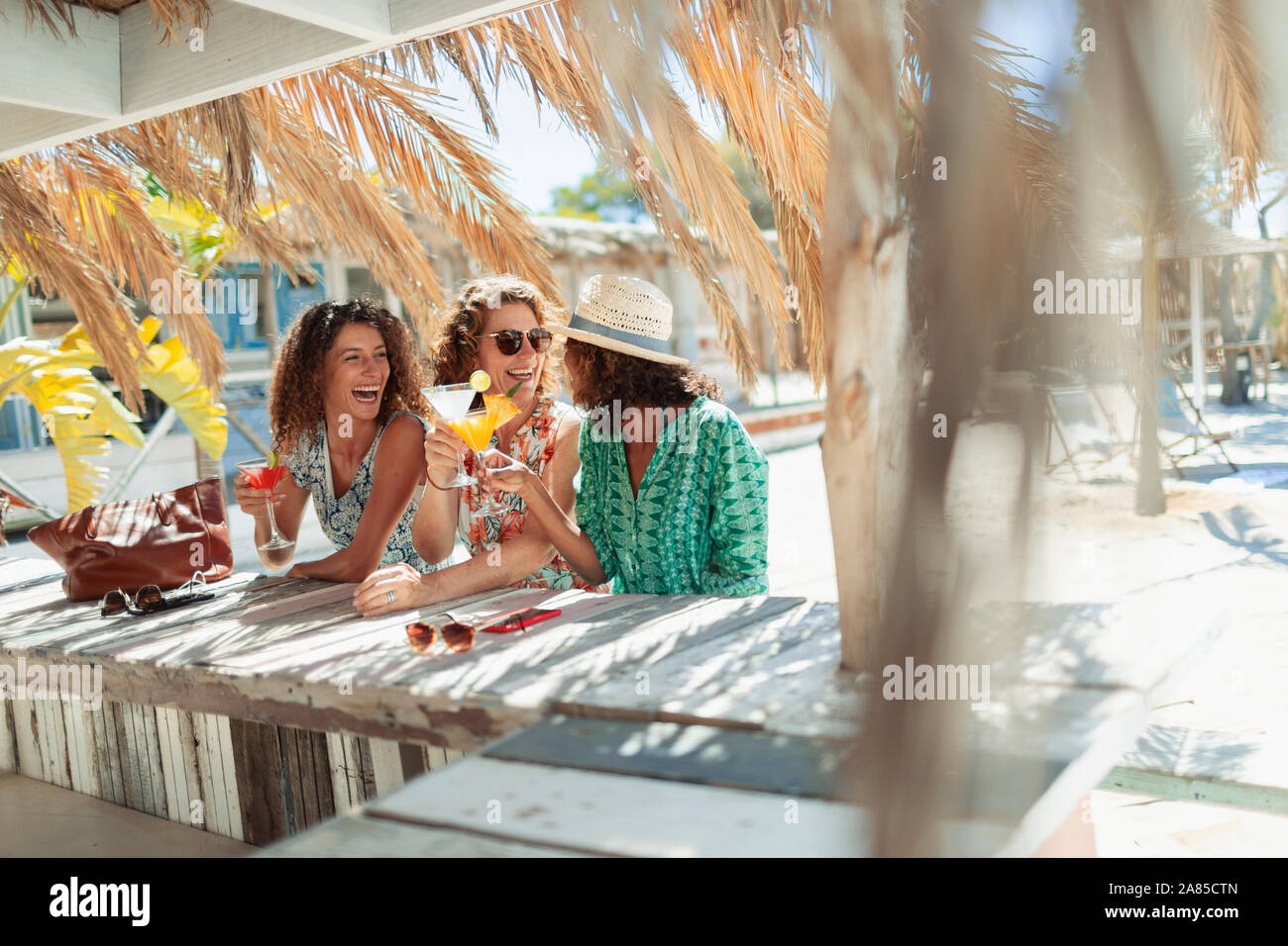 Heureux les femmes de boire des cocktails au bar de la plage ensoleillée Banque D'Images