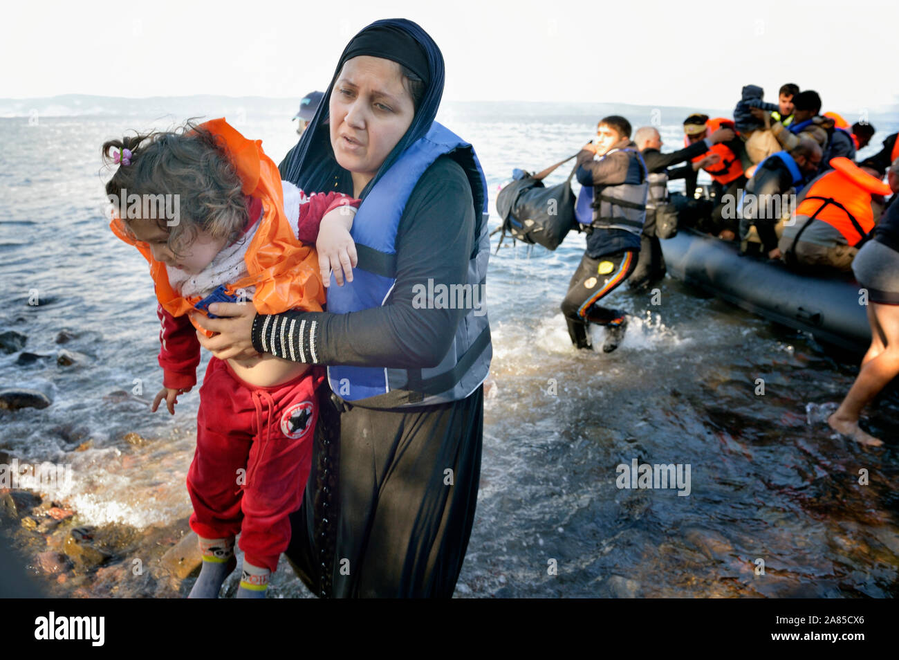 Un réfugié mère porte sa fille à terre sur une plage près de Molyvos, sur l'île grecque de Lesbos, le 29 octobre 2015. Banque D'Images