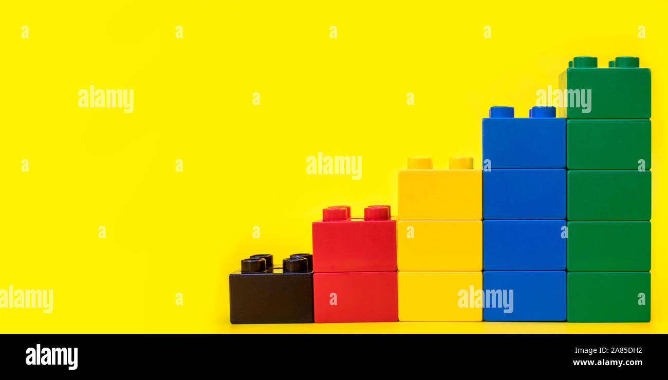 Blocs de construction en plastique Bar graphes toy briques sur fond jaune avec place pour vous les textes et contenu. Banque D'Images