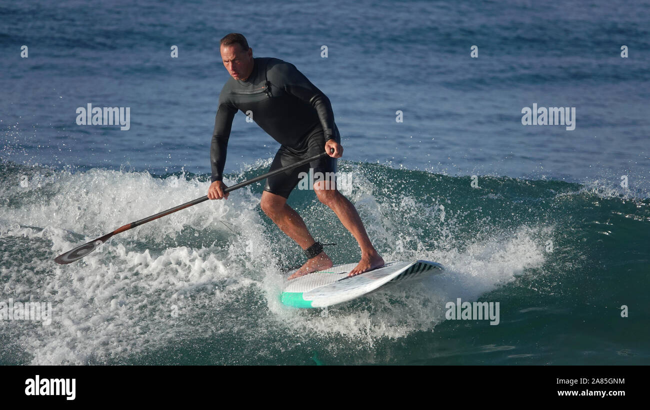 L'homme athlétique (52 ans) reste en forme et actif sur un surf SUP (stand up paddle board) Banque D'Images