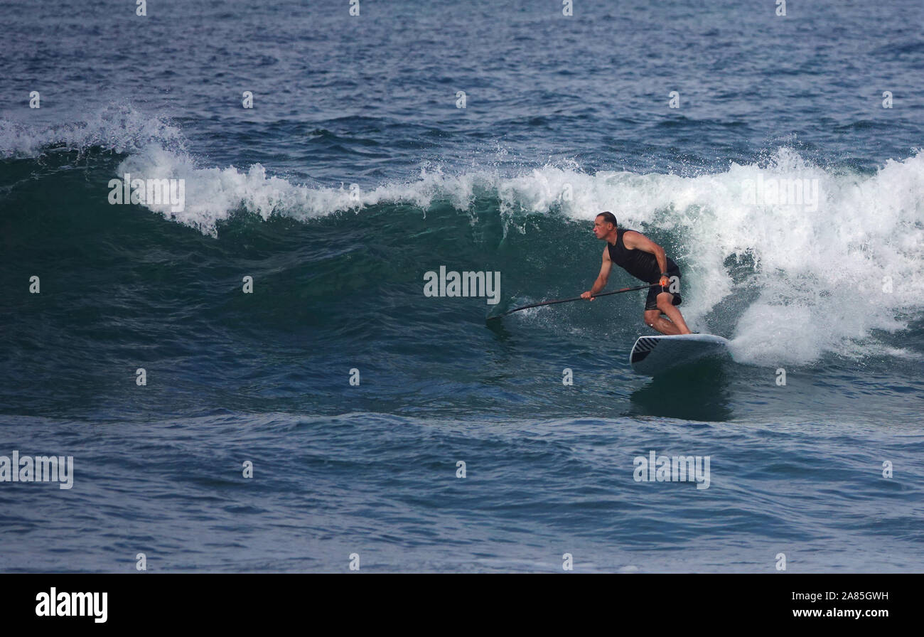 L'homme athlétique (52 ans) reste en forme et actif sur un surf SUP (stand up paddle board) Banque D'Images