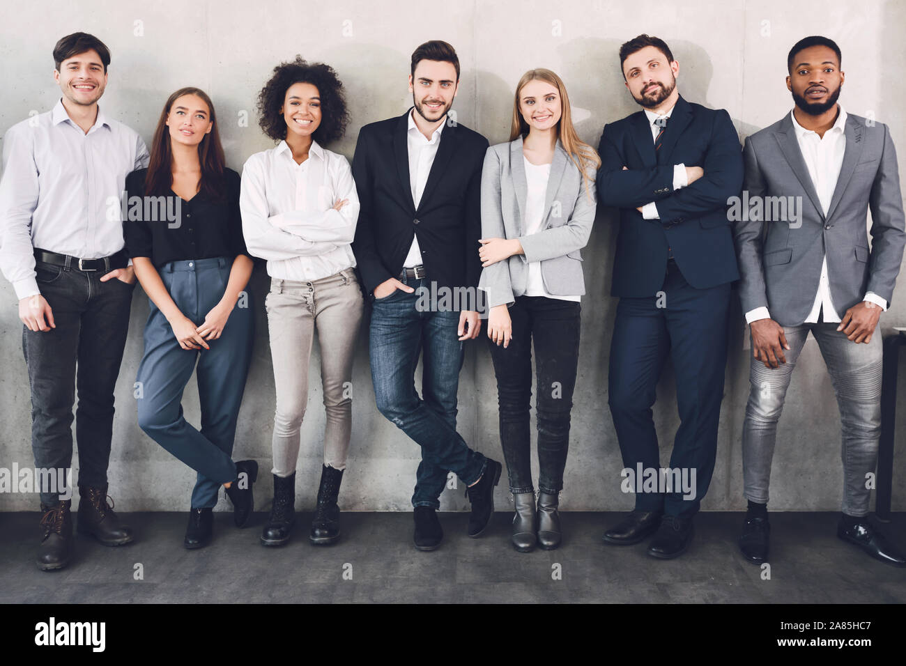 Les jeunes collègues d'affaires smiling together à l'appareil photo Banque D'Images