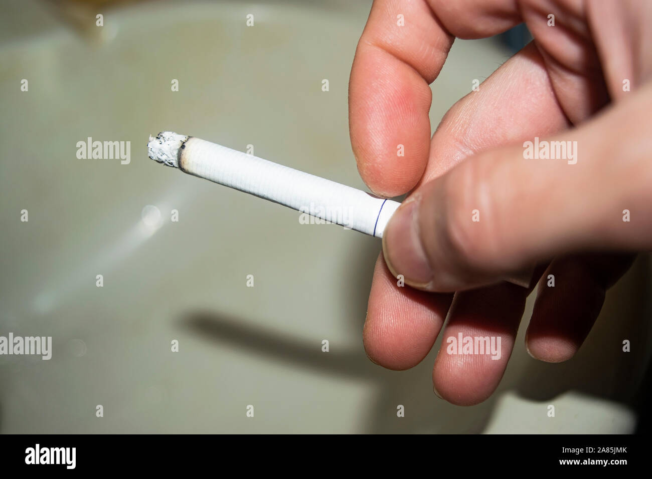 Cigarette dans la main d'un homme concept photo. Les dangers du tabagisme. Mode de vie sain. Le rejet des mauvaises habitudes Banque D'Images