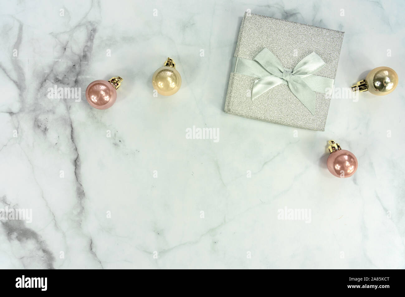 Cadre de Noël sur fond d'argent avec des ornements de décoration en marbre et boîte-cadeau Banque D'Images