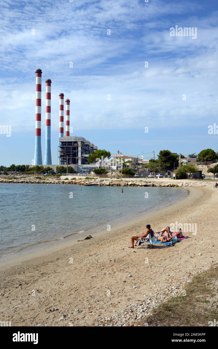 Plage, les touristes et les baigneurs à la plage Les Laurons Martigues & Centrale thermique EDF ou de centrales électriques, Ponteau Provence France Banque D'Images