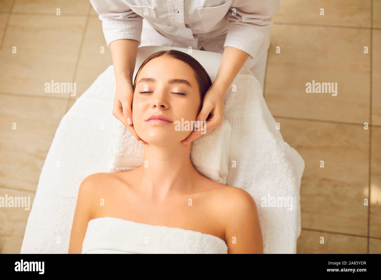 Massage du visage de jeune femme de près. Banque D'Images