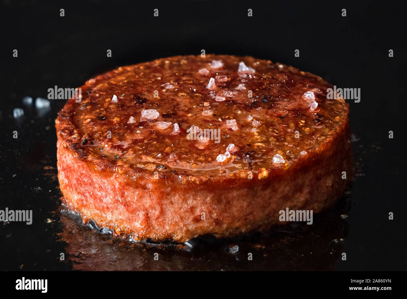 Burger végétarien à base de plante patty avec du sel de roche par cuisson sur gril de fer noir. Banque D'Images