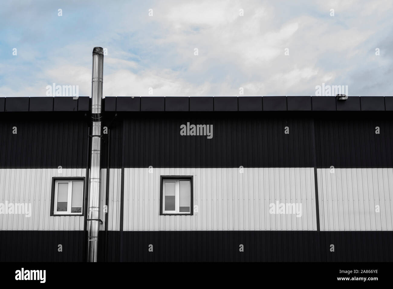 Noir et blanc surface texture feuille de métal ondulé sur la paroi d'un immeuble avec windows. Fond en acier galvaniser. Banque D'Images