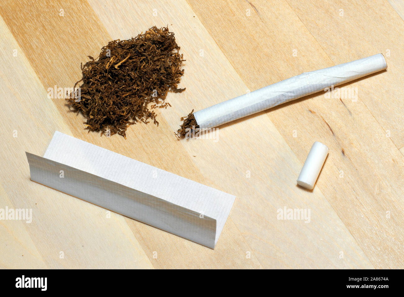 Accessoires pour fumer (tabac, papier filtre) pour rouler cigarette sur  fond de bois Photo Stock - Alamy