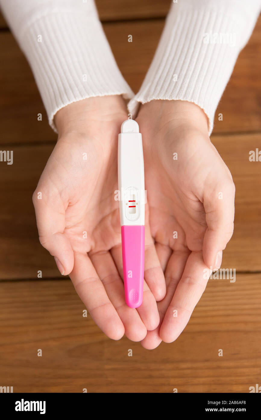 Femme hands holding test de grossesse positif Banque D'Images