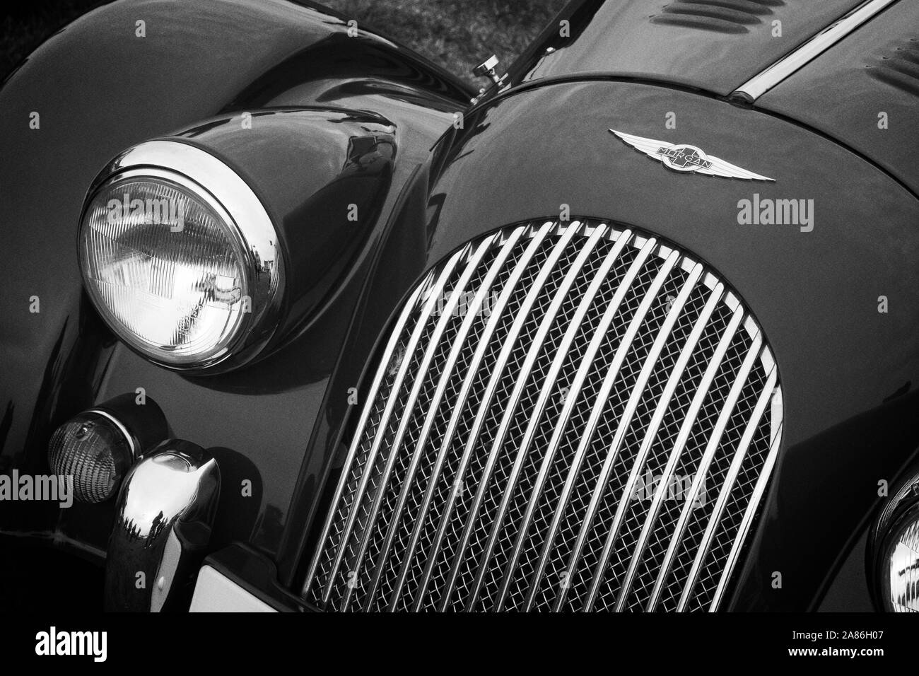 Détail de l'avant une voiture de sport rouge Morgan montrant un insigne, calandre, phare et témoin. Banque D'Images