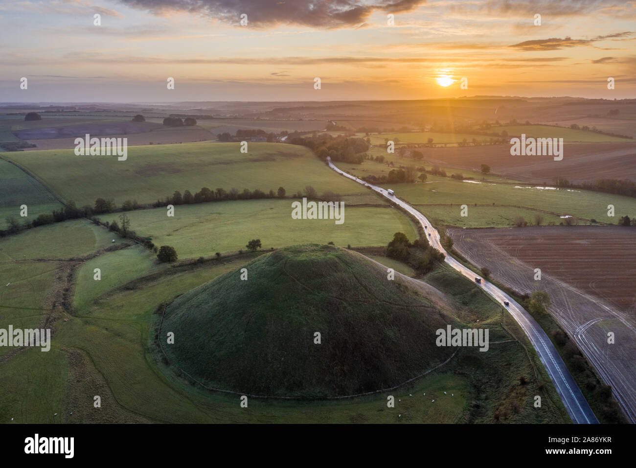 Silbury Hill, Nr Avebury, Wiltshire, Royaume-Uni. 4 novembre 2019. Image Drone le lever du soleil au-dessus de la butte du néolithique Silbury Hill dans le Wiltshire. Banque D'Images