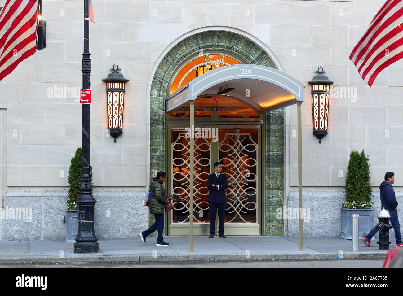 Un portier en face de 220 Central Park South Hotel, New York, NY. Banque D'Images