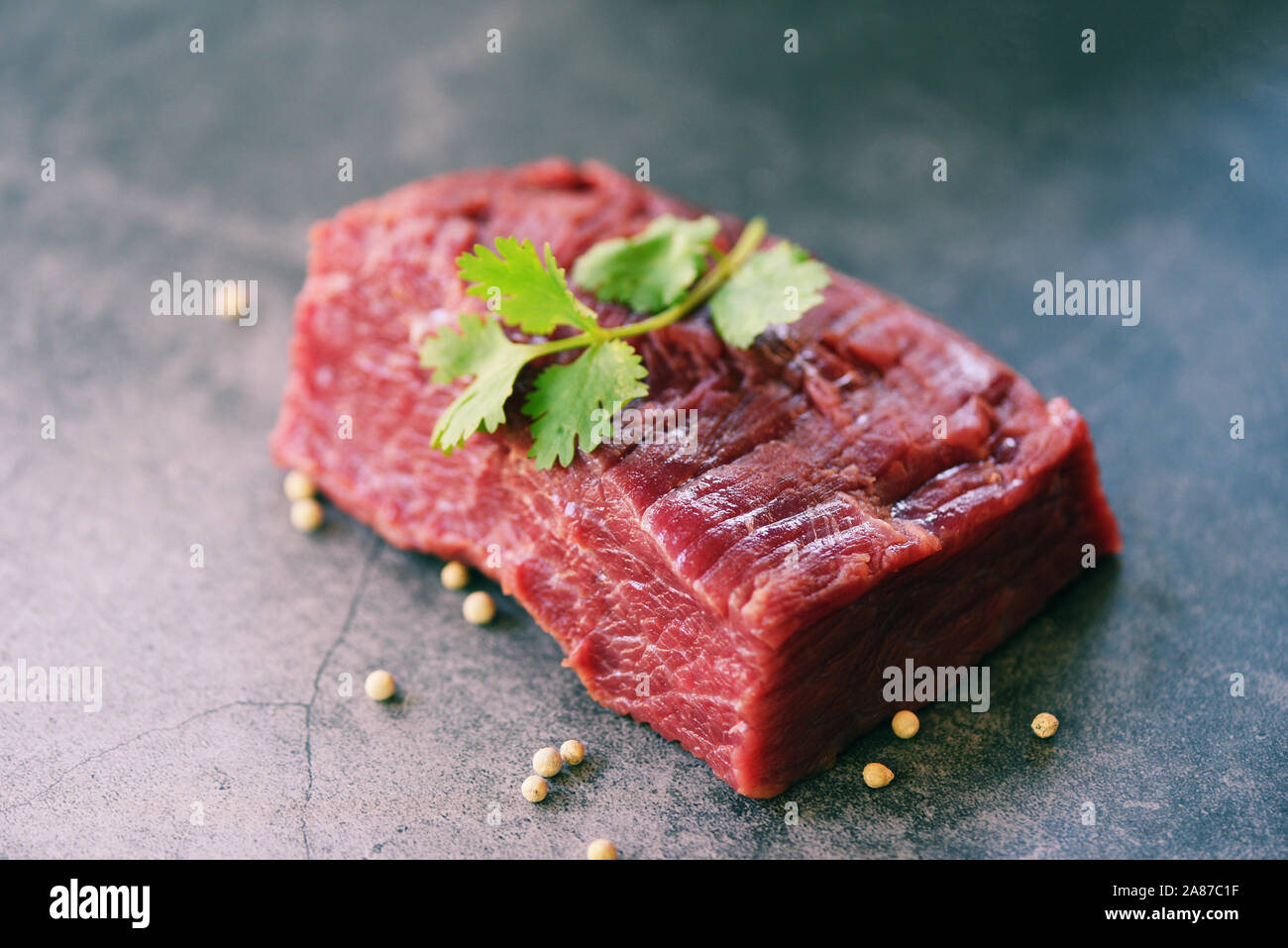 Les viandes steak de boeuf aux épices ail sur planche à découper en bois et fond noir, vue du dessus / morceau de boeuf frais ou grillé steak pour barbecue Banque D'Images