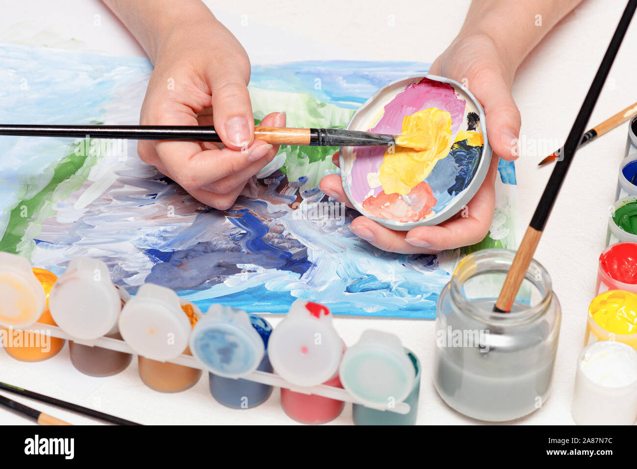 Un peintre amateur est un dessin en peinture gouache sur fond de table blanc close up. Banque D'Images