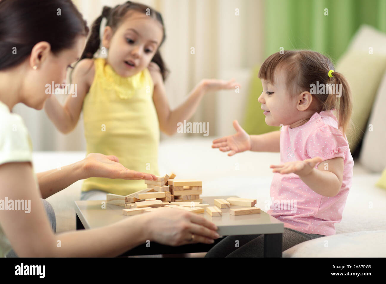 Mère de famille et enfants à la table de jeu de société Jeu Banque D'Images