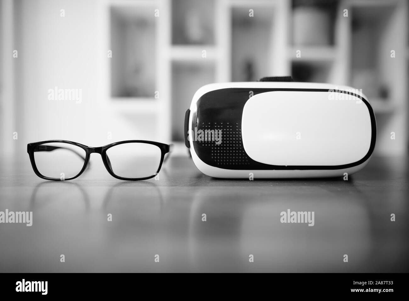 Les lunettes et casque de réalité virtuelle qui met sur la table en bois Banque D'Images