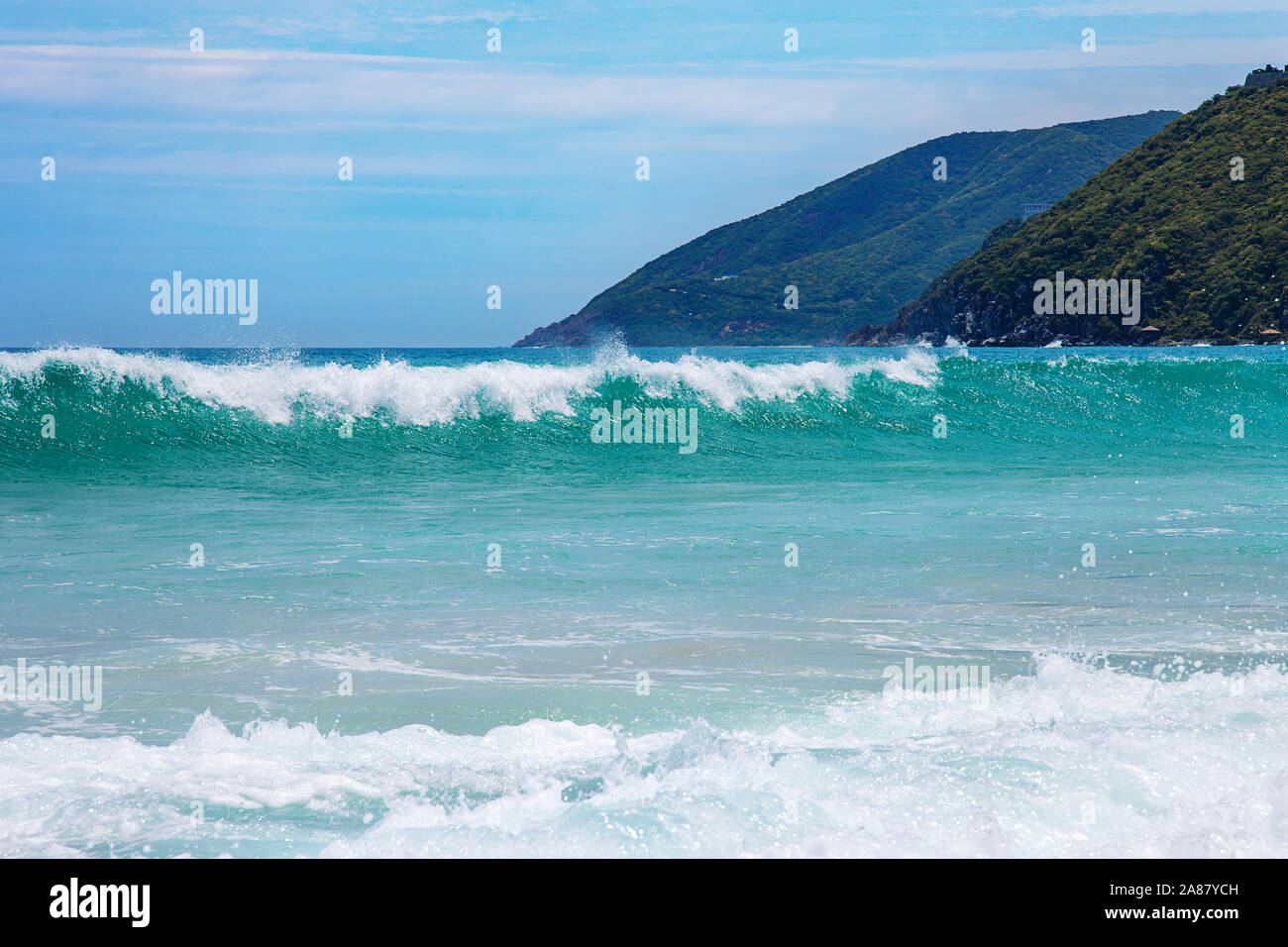 Vague bleue de la mer avec mousse blanche et ciel Banque D'Images