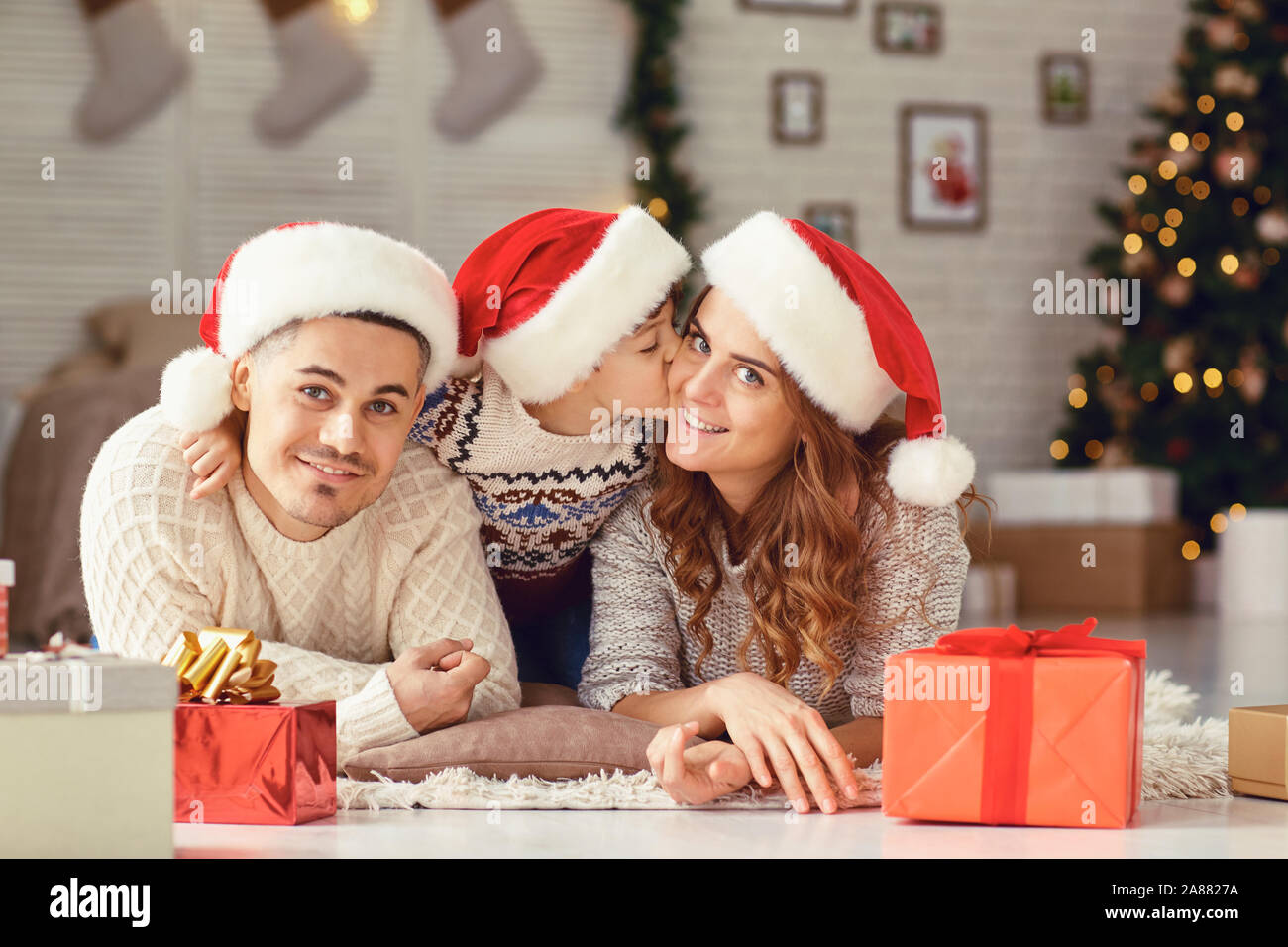 Happy Family smiling allongée par terre dans Noël. Banque D'Images