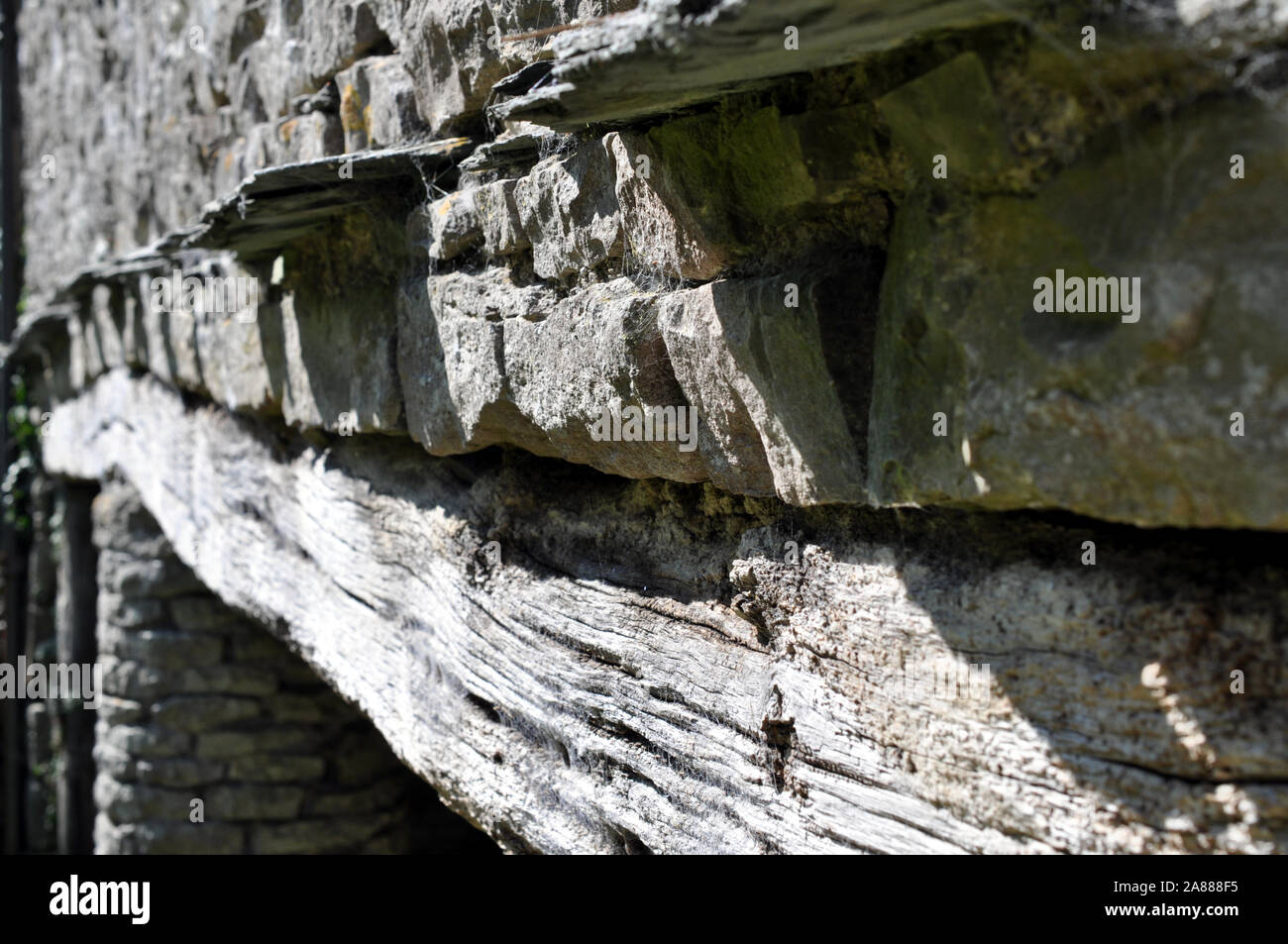 Photo en perspective d'un linteau en bois dans une ancienne grange en pierre avec une ardoise ridge Banque D'Images