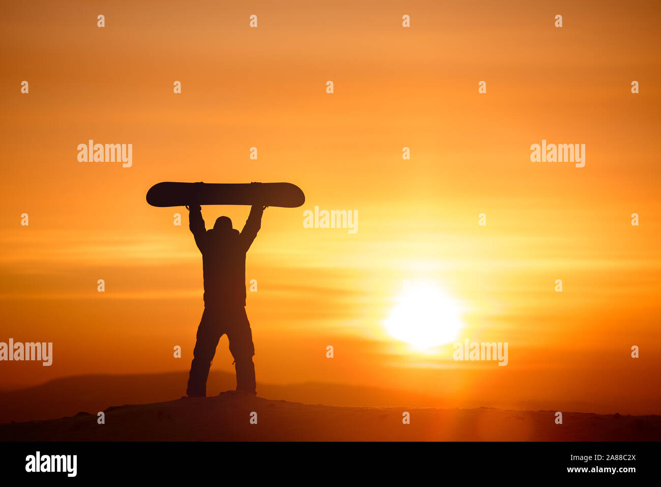 Planche de snowboard est au-dessus de la tête sur fond de coucher de soleil et ciel. Concept de ski Banque D'Images