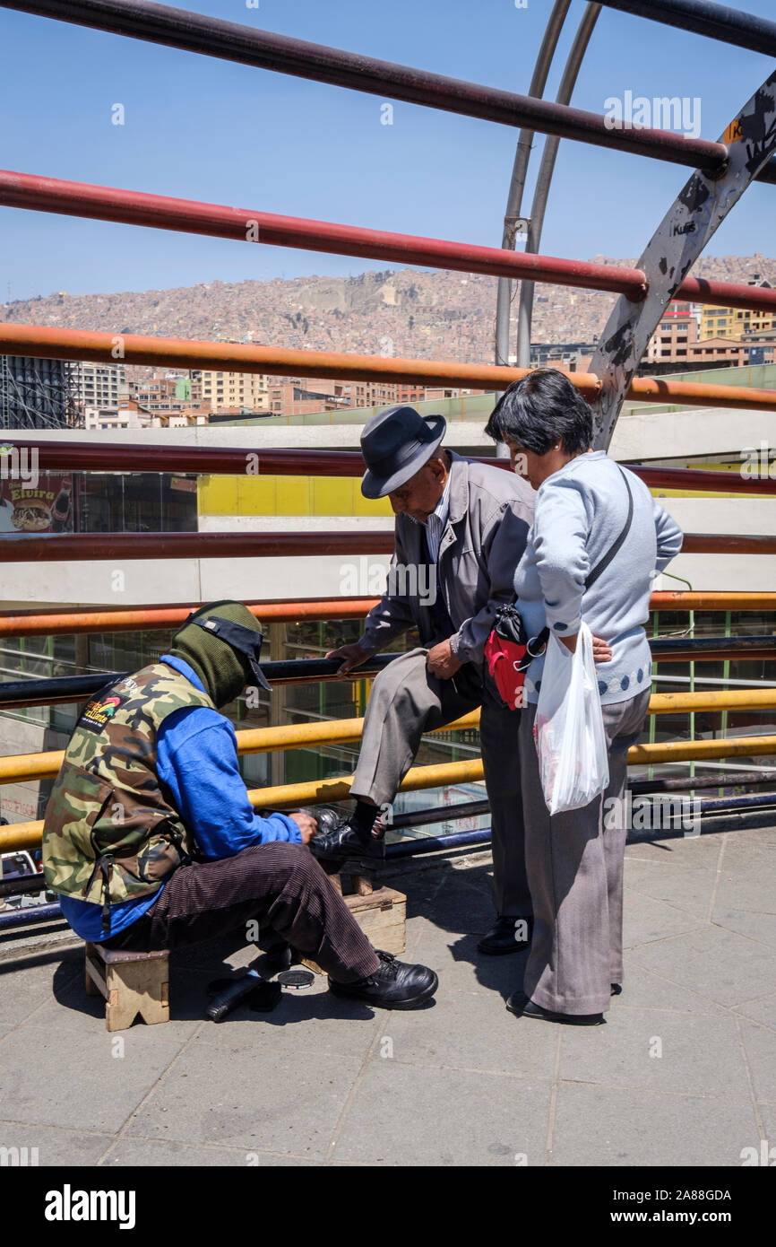 Les hommes se cachent de cirage son visage derrière un masque de honte dans le centre-ville de La Paz, Bolivie Banque D'Images