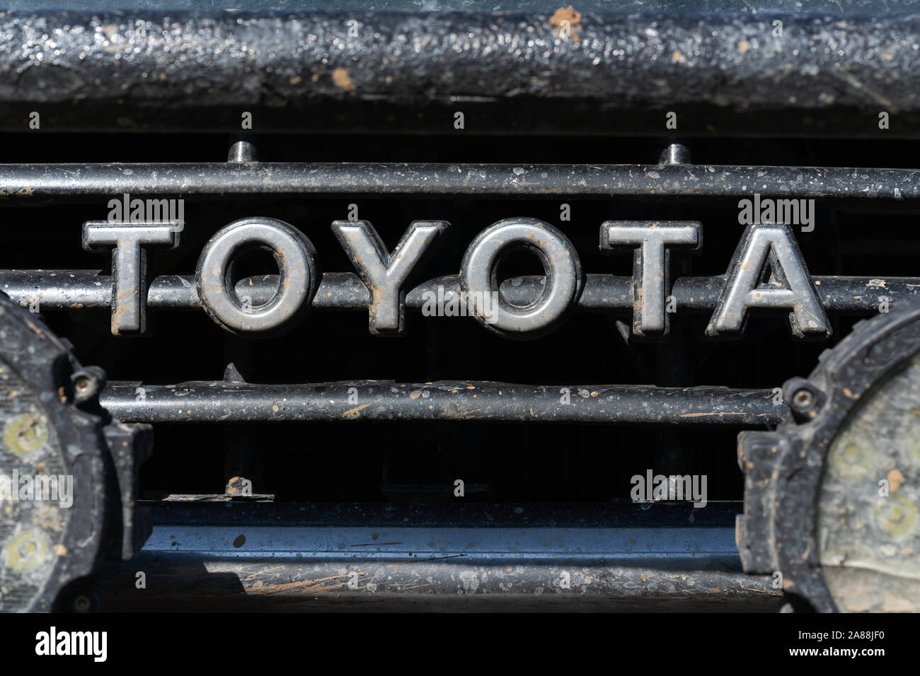 Vue rapprochée de l'ancien auvent minable avant de Toyota Land Cruiser Prado avec l'inscription Toyota - marque de fabricant japonais de voitures hors-route Banque D'Images