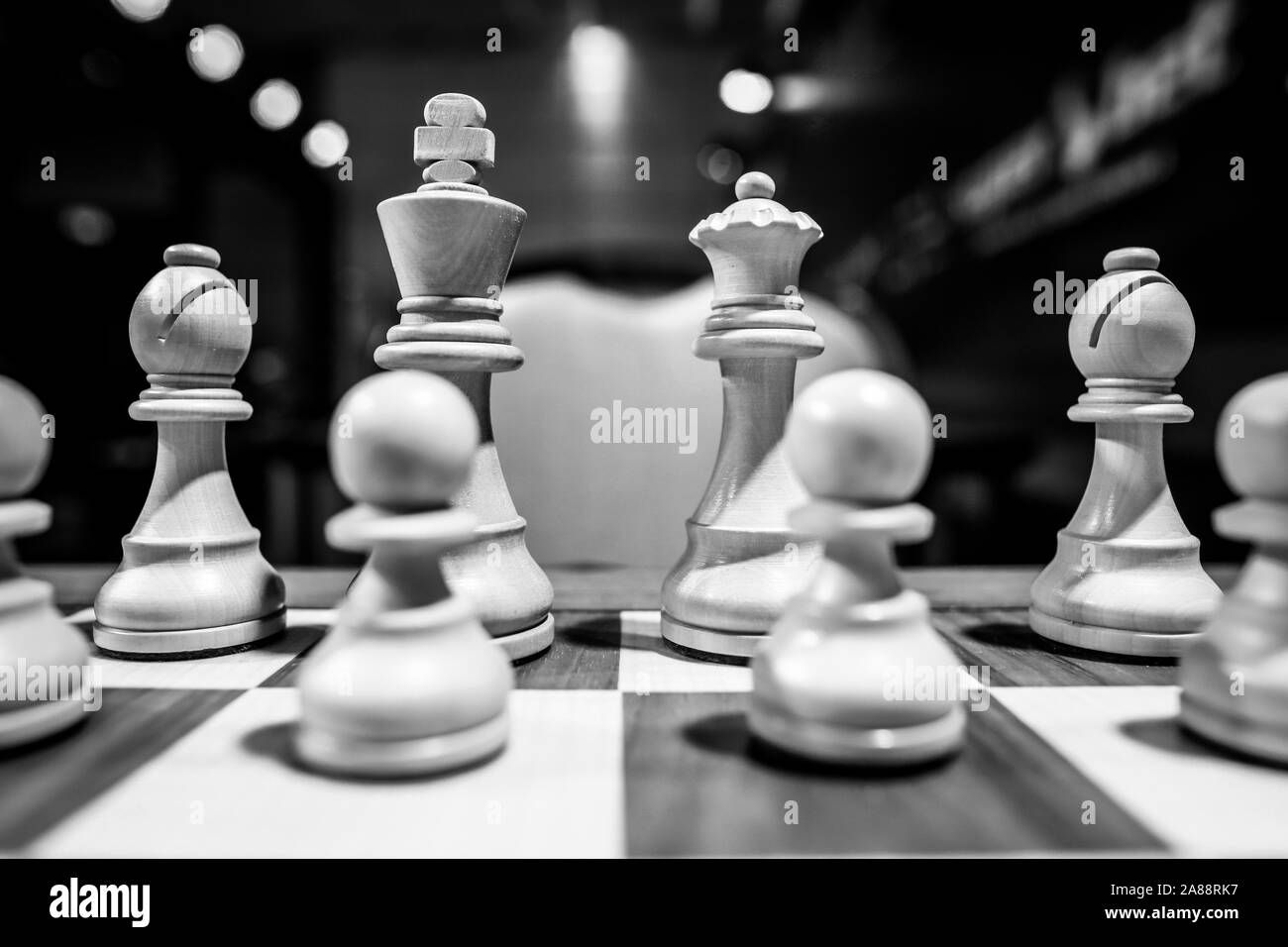 Profondeur de champ monochrome (selective focus) image avec pièces d'échecs en bois sur une table en bois avant une compétition professionnelle. Banque D'Images