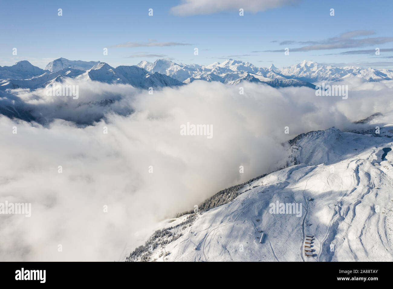 Vue aérienne d'une forêt couverte de neige fraîche et nuages dans le domaine d'Aletsch Arena. La Suisse à l'automne Banque D'Images