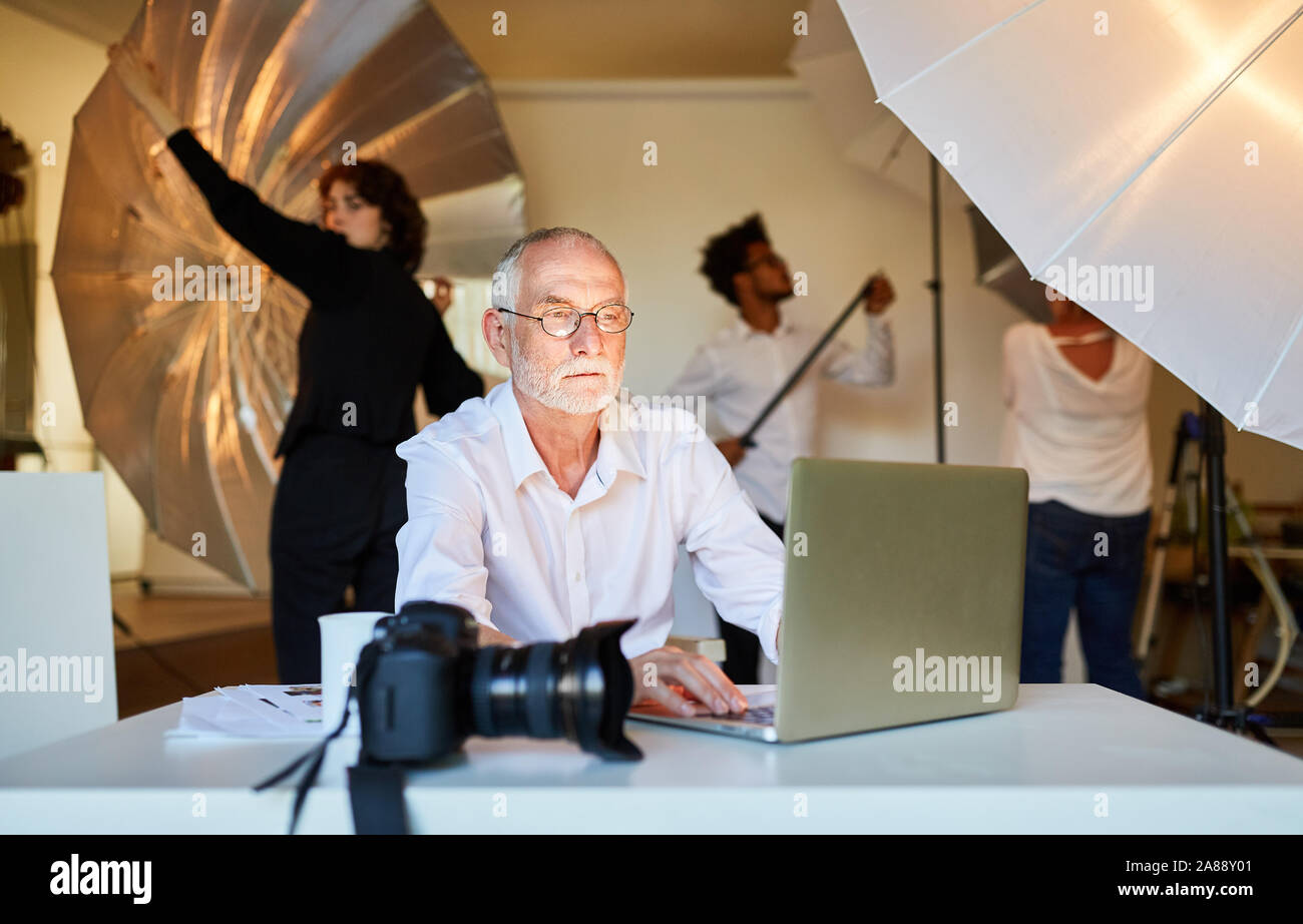 Photographe expérimenté en post-production sur l'ordinateur portable au cours de la retouche d'image Banque D'Images