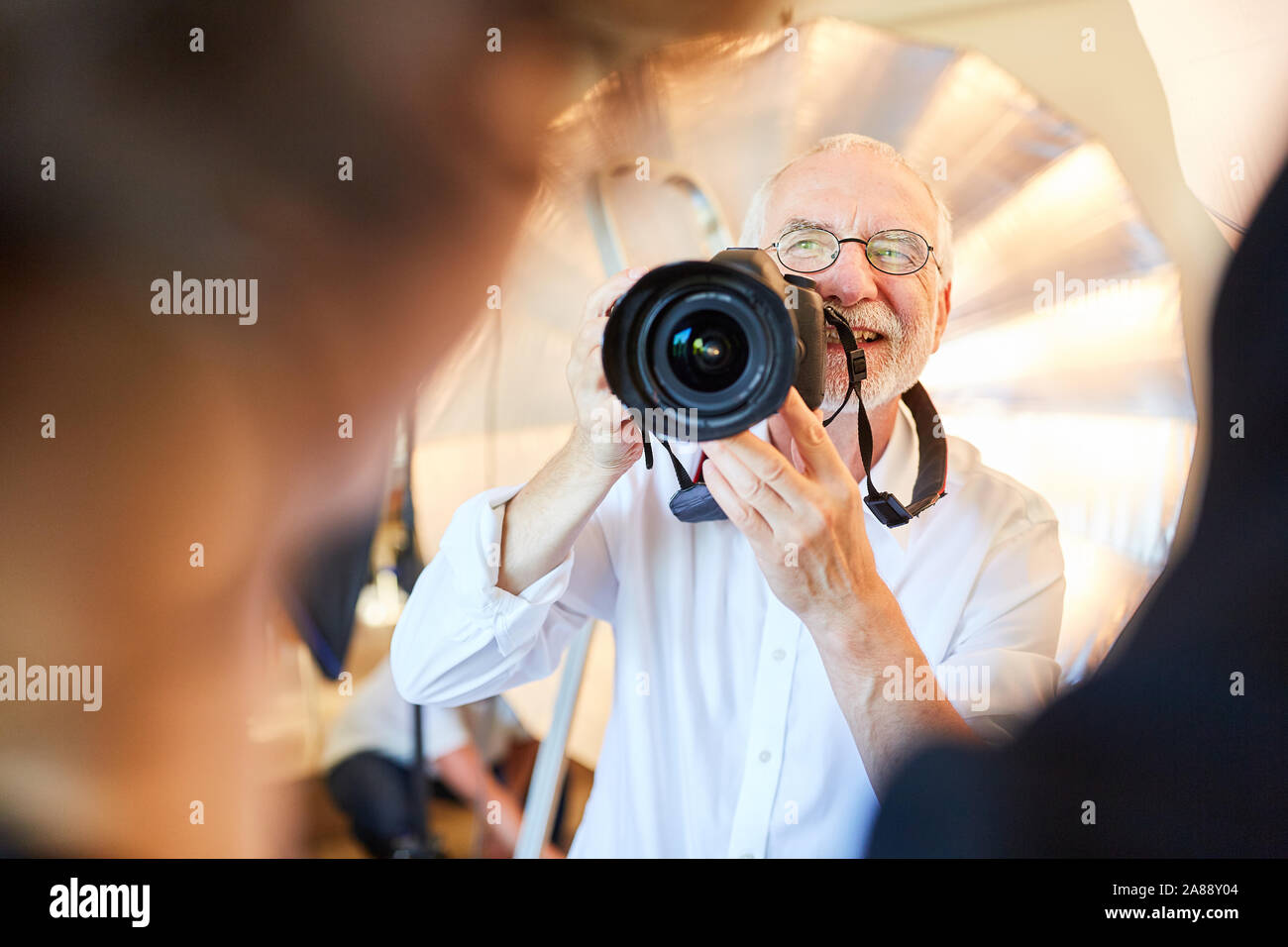 Photographe senior avec appareil photo numérique prend des photos d'une femme Banque D'Images