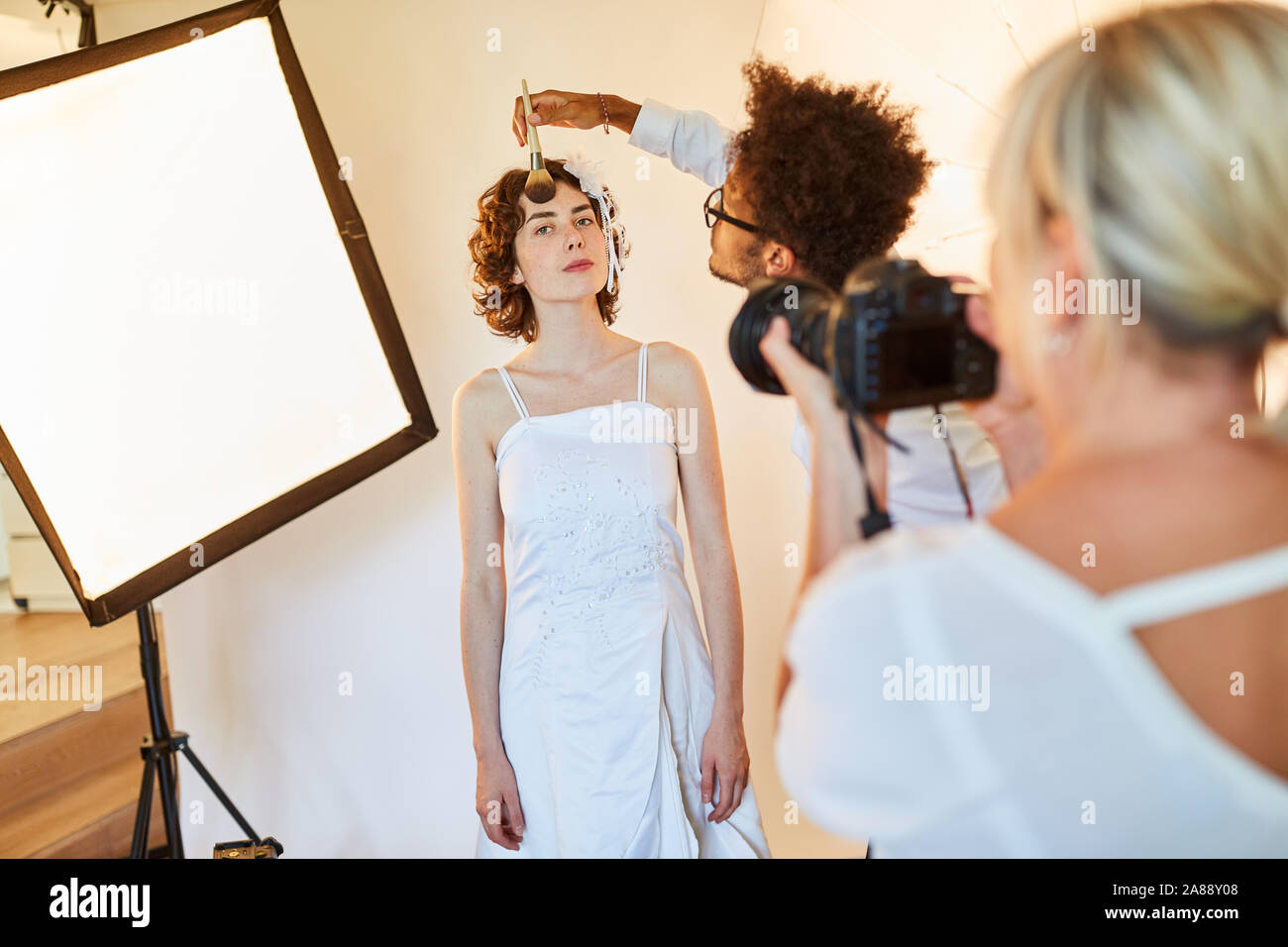 Maquilleuse ou maquilleur appliquant le maquillage d'une mariée dans un studio photo Banque D'Images