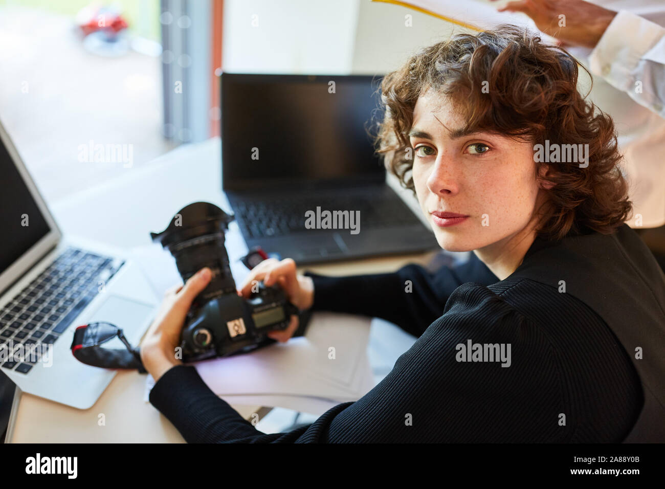 Photographe indépendant avec caméra et ordinateur portable de la photo studio Banque D'Images